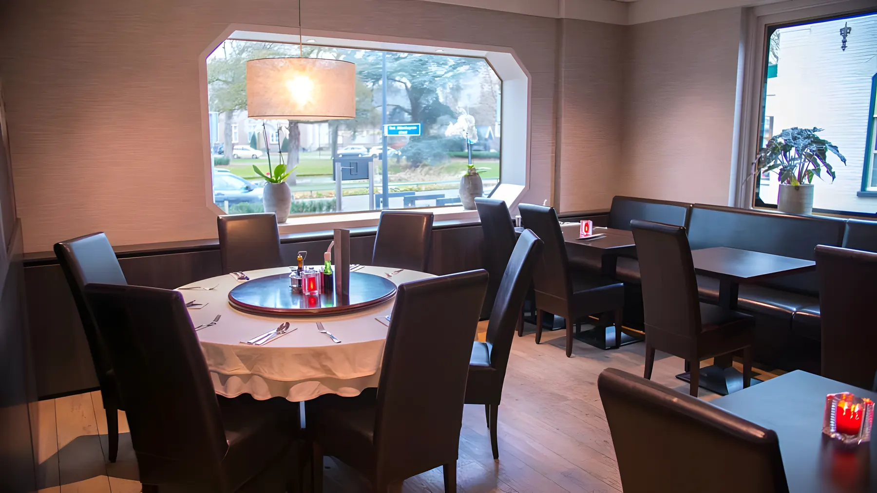 Ronde tafel met draaiplateau bij het raam, uitzicht op het park