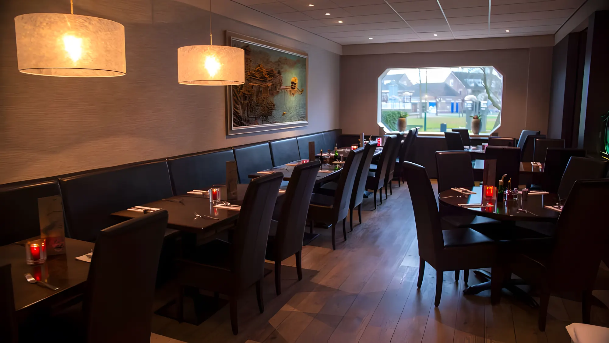 Het restaurant met ronde lampen en uitzicht op het park